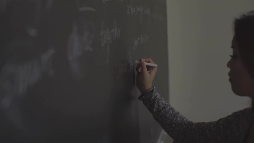 Woman writing on chalkboard