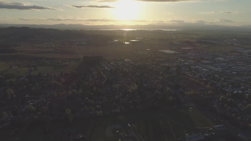 The sun rising over a small town and trees