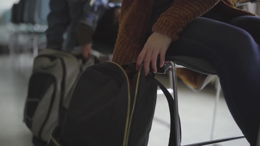 Students pulling things out of their backpacks in class