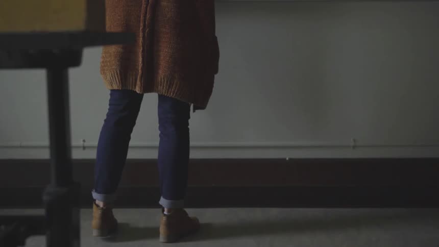 A woman is standing in a classroom