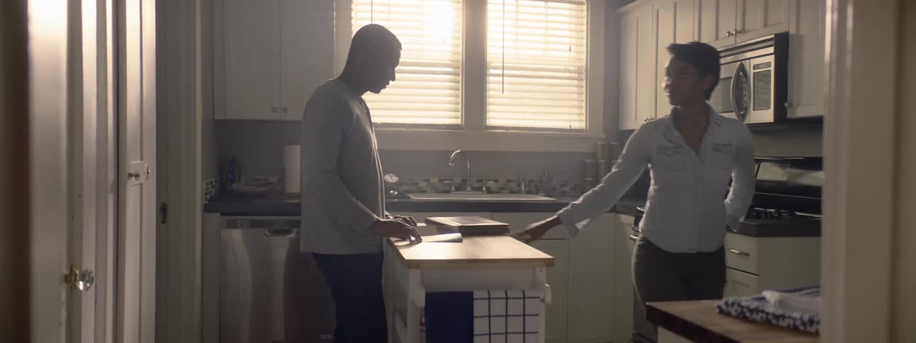 A woman taps on the counter before walking out of the kitchen and leaving her husband behind