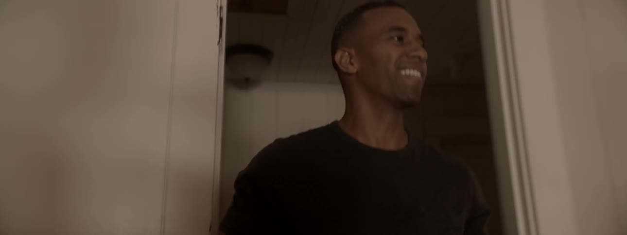 A man walks into a room and smiles