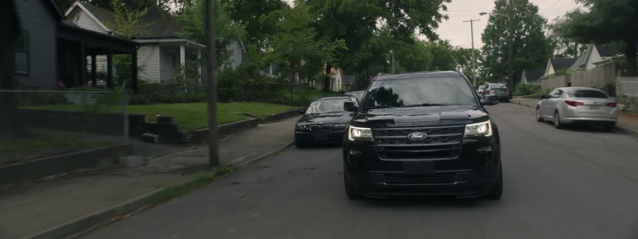 Dark ford suv drives in neighborhood