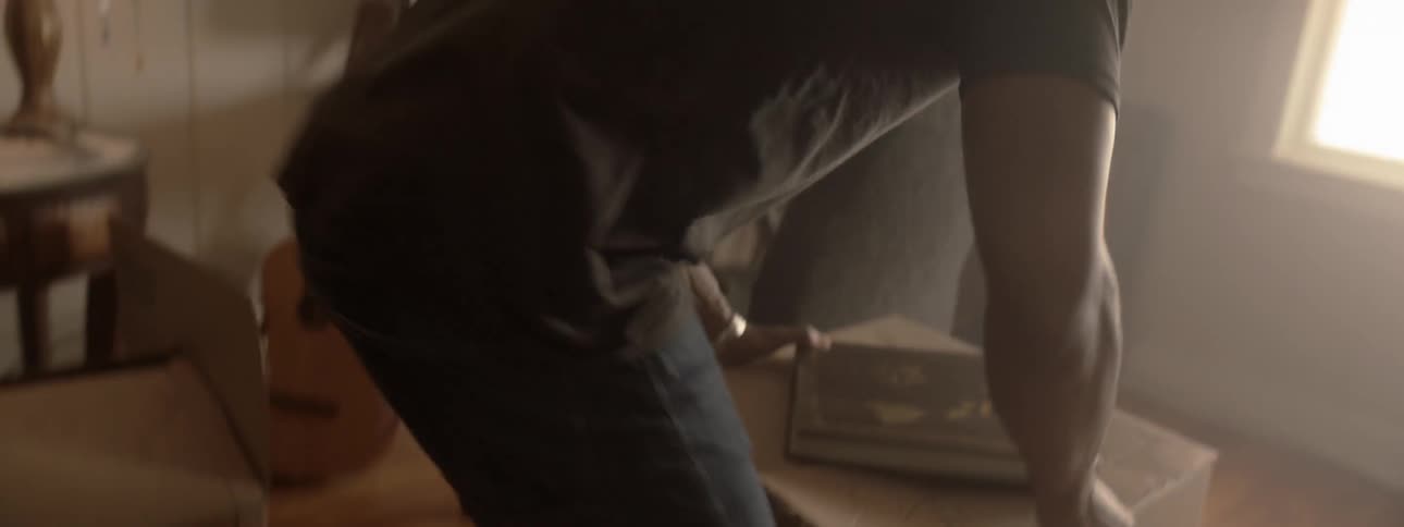Man carries ottoman near chair
