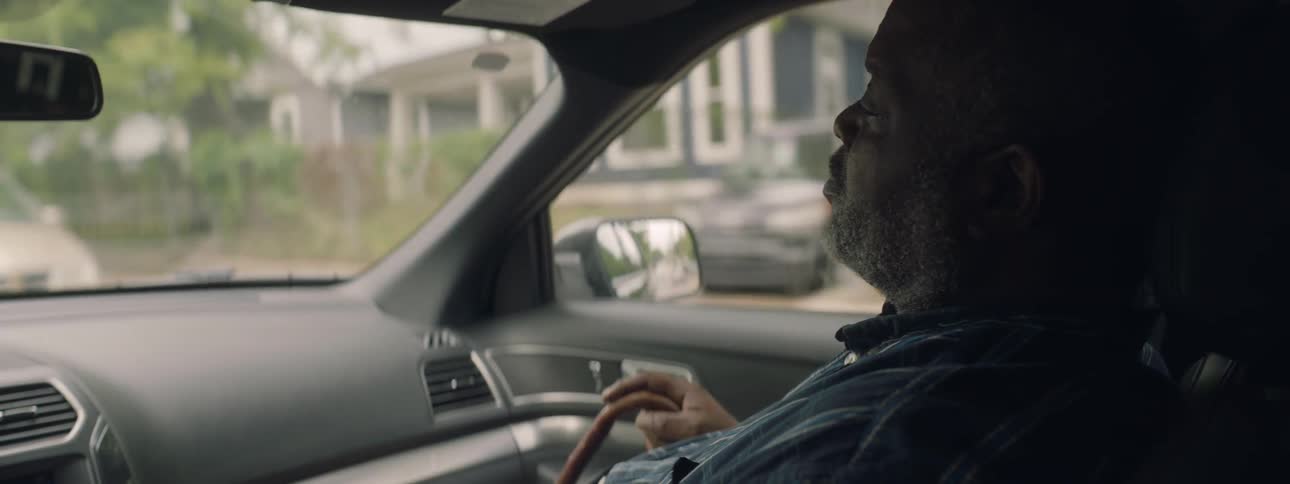 Man holding cane rides in passenger seat of car