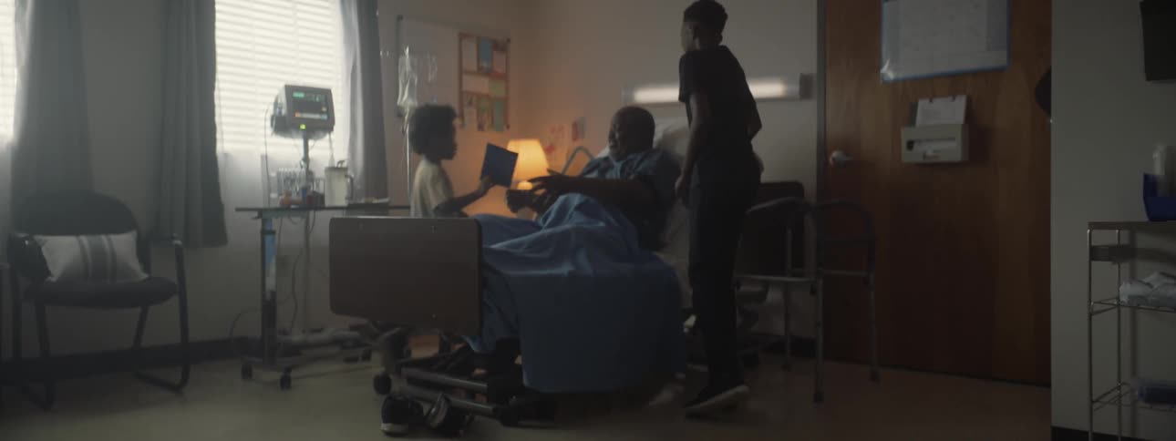 Two children rush in to see their relative in a hospital bed