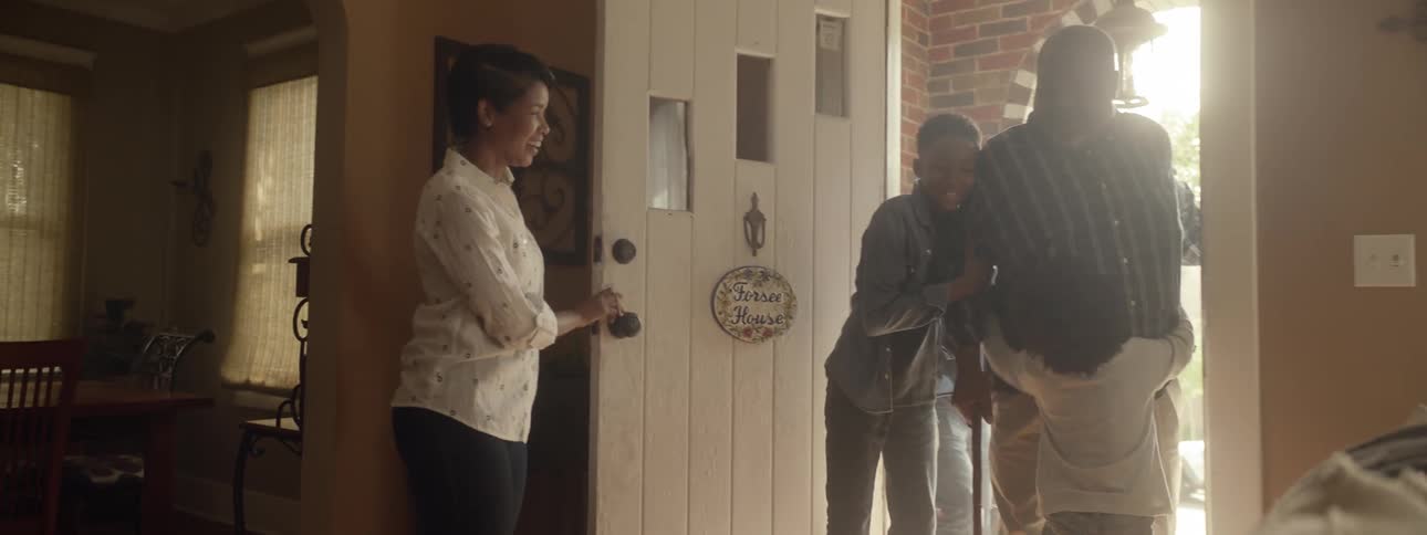 Family greets grandfather as he enters house