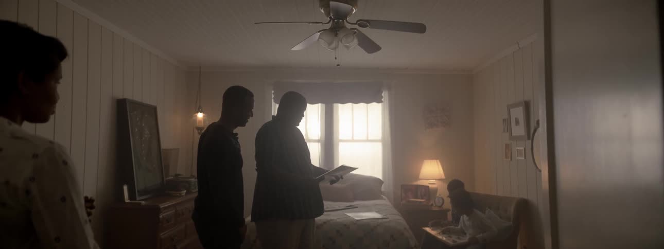 A family looks at pictures in a bedroom