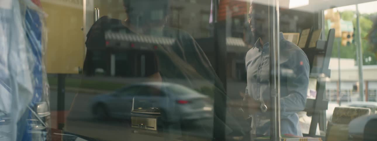 View through window of man buying suit jacket