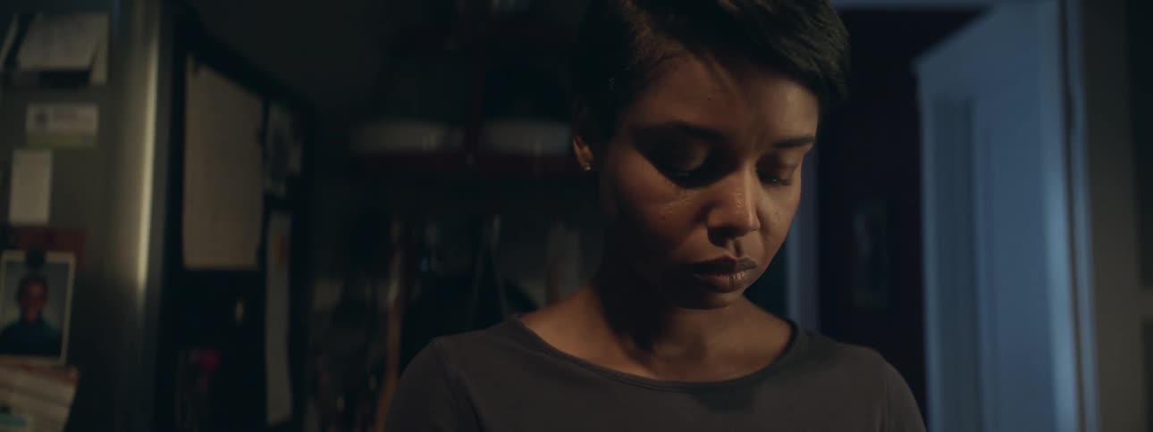 A young black woman standing in a dark room