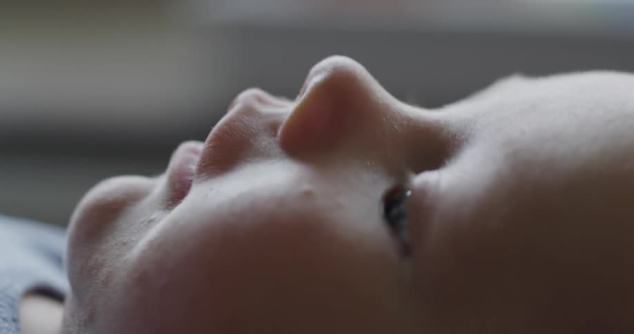 A baby lying  on its back looking around