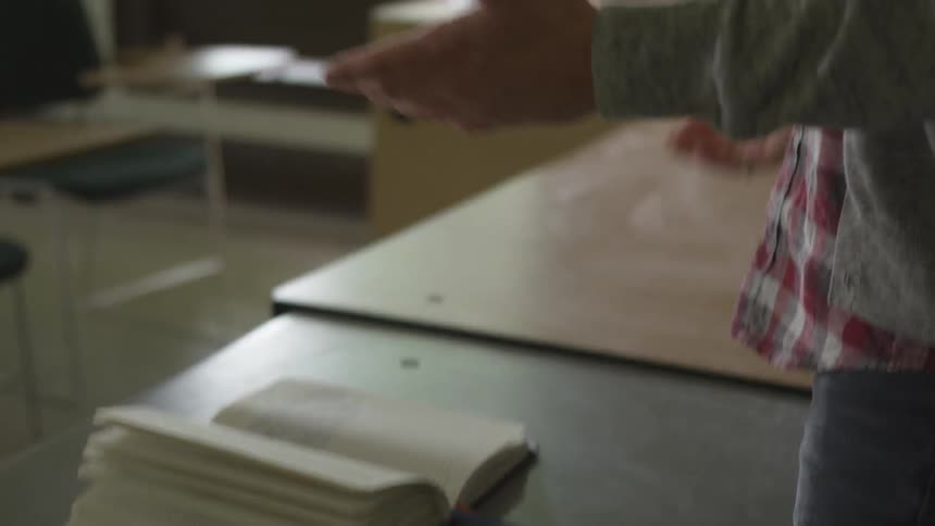 Teachers arms as the gesture about book on table in front of them