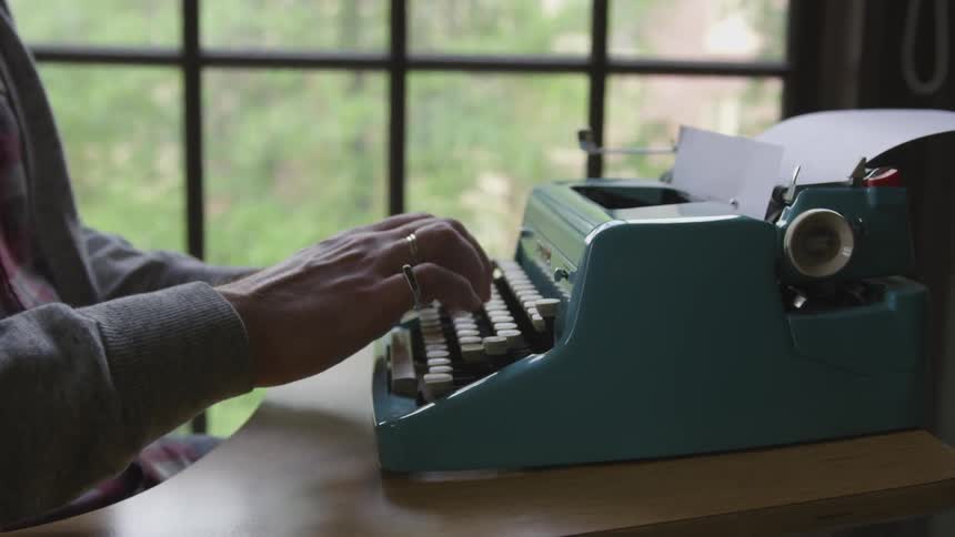 A person typing on an old typewriter