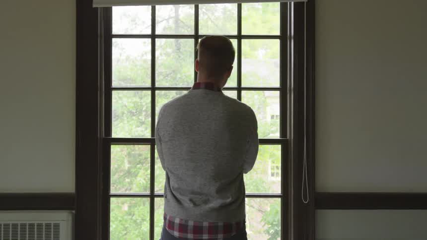 Man faces window and looks ahead and to the side