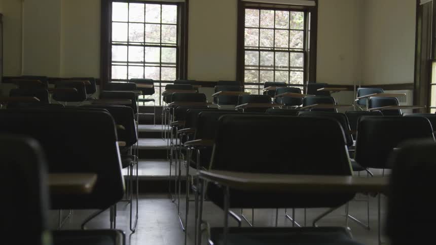 A classroom with chairs and desks and large windows