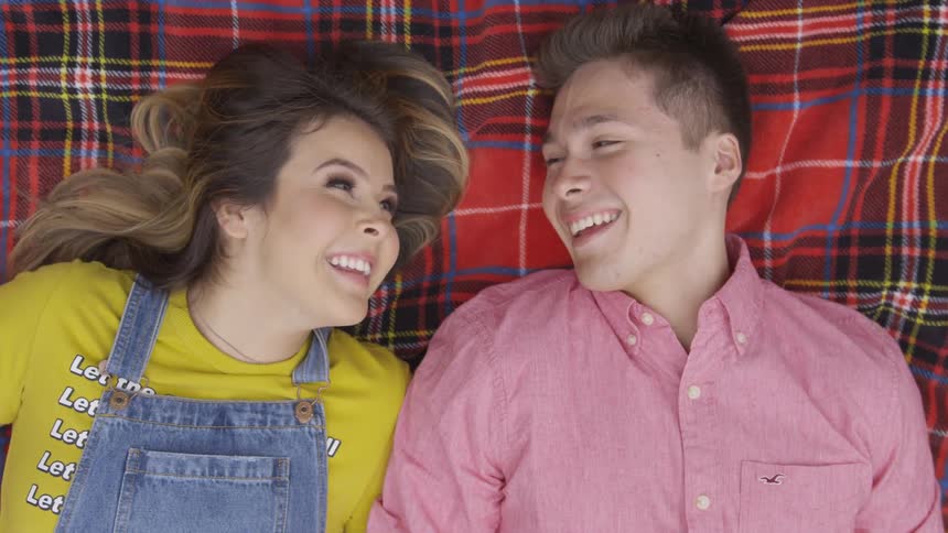 A man and woman lay in a blanket together