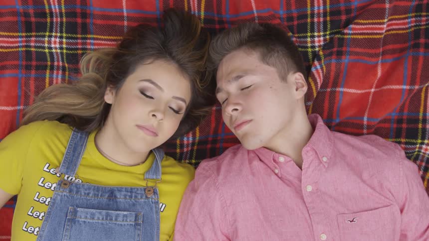 Woman and man lies down and sleep on the rug outdoors