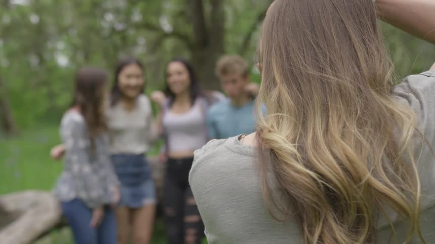 Woman photographs four others outdoors