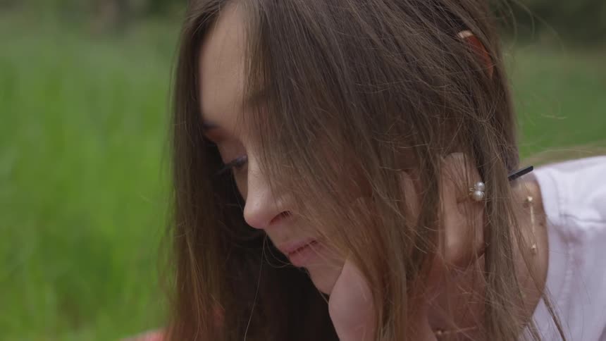 A woman is laying in the grass outdoors