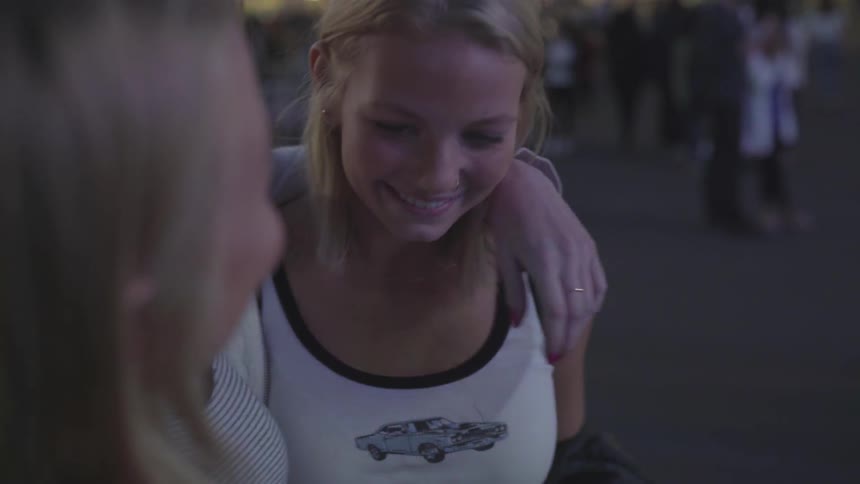 A group of laughing white females at a carnival during the night