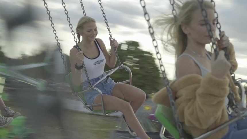 Two girls on a large swing
