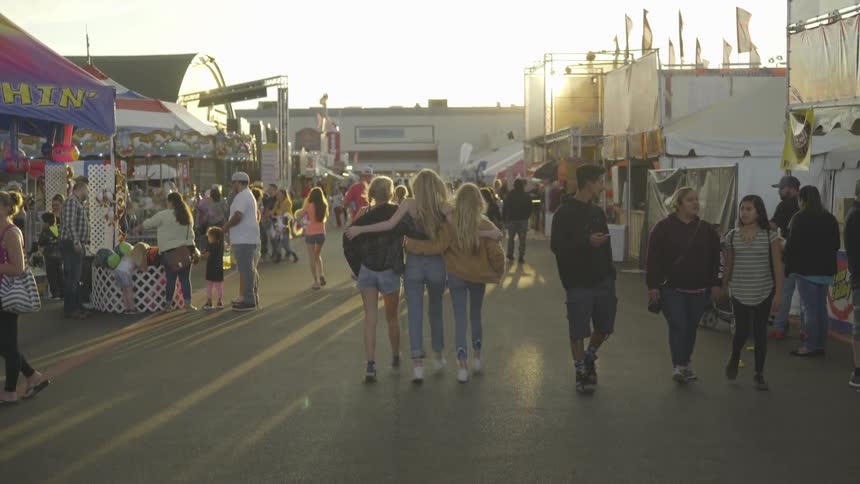 Girls walking together down a carnival pathway