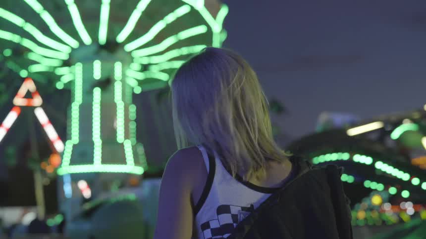 Back of girl looking at rides at amusement park