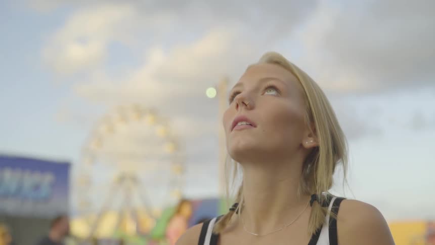 Woman looks up toward sky at carnival