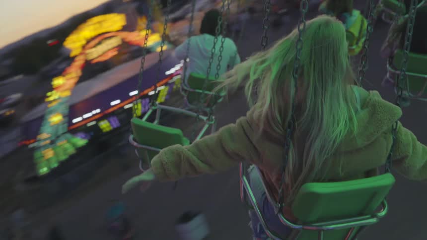 Woman rides the fair swing with several other people