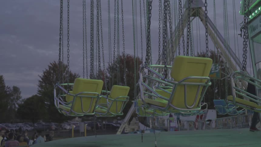 Empty amusement park ride chairs swing around