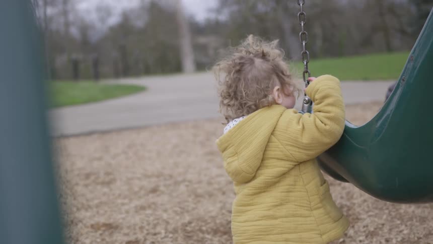 Girl playing with a swing on a playground