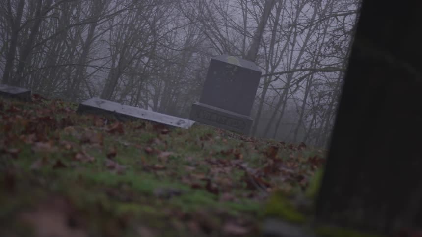 Gravestones surrounded by fog on a graveyard
