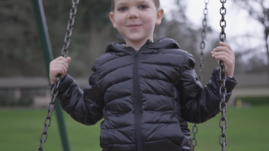 Boy swings in park during the day