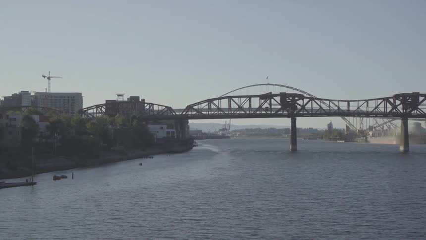 Crossing a bridge watching over a large river next to a city