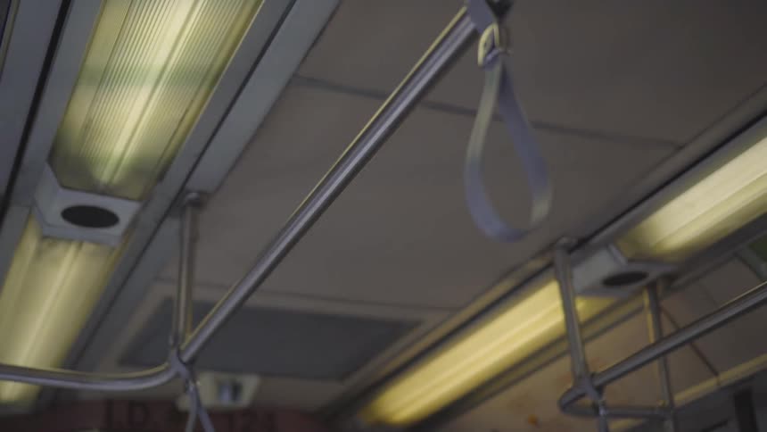 Camera focused on the handrail on the ceiling of public transportation