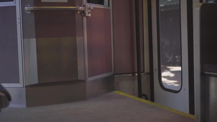 Street and station pass by outside train door