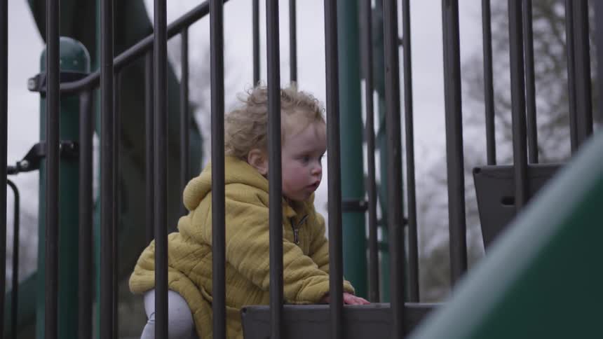 A climbing the stairs of a playground on a park