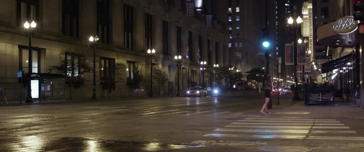 Cars drive on a city street at night