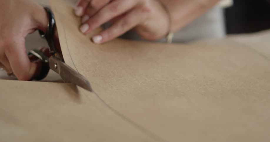 A person cutting paper with a pair of scissors