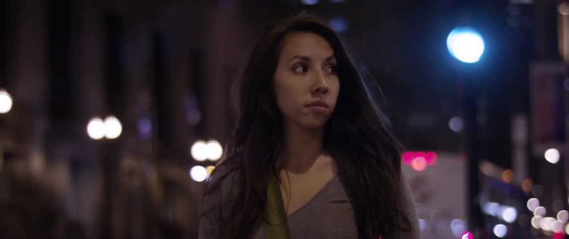A woman walks through the city at night