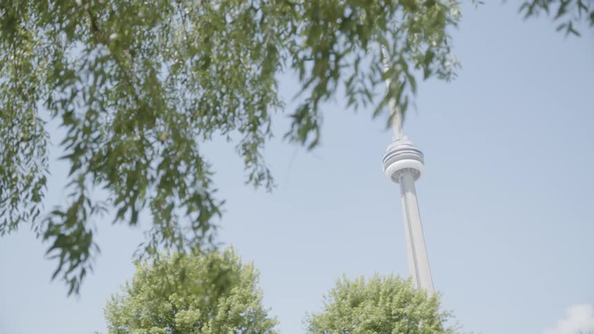 Black man contemplating a tall tower while sitting at the park