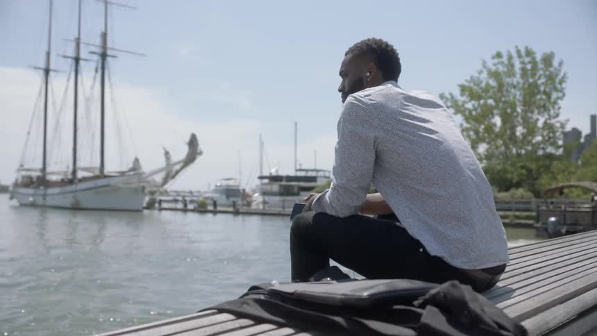 A man is sitting on a bench outdoors