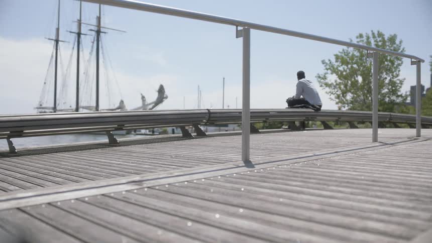 A man sitting on a bench by the pier