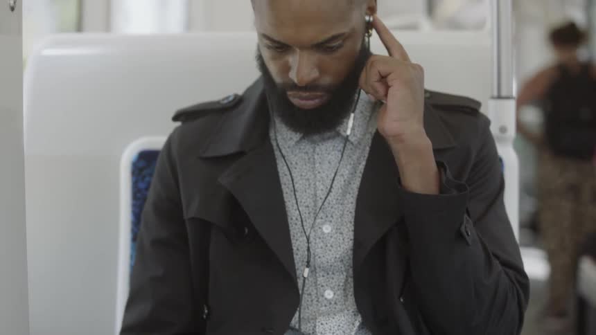 Black man playing on phone listening to music