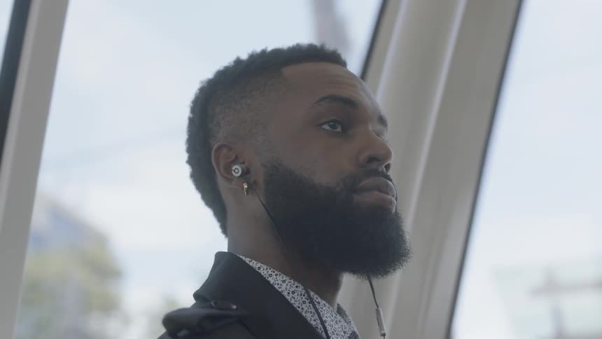 Man turns his head while wearing earbuds