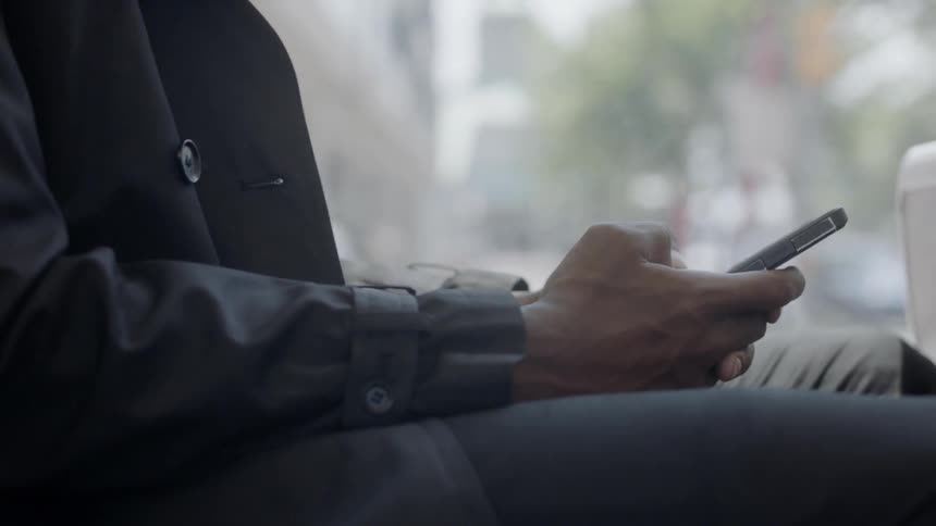 Person sitting in mass transit transportation plays with cell phone