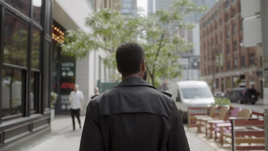A man walking down the sidewalk in the city