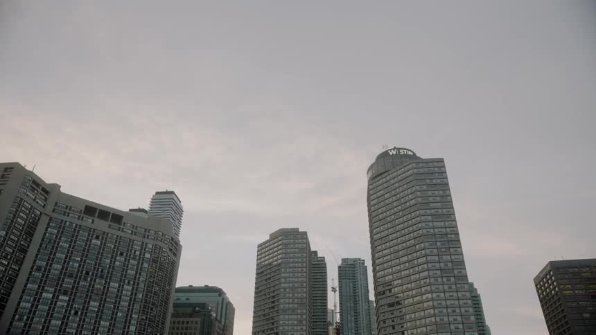 The buildings of Toronto's harbour square park stand tall against a cloudy sky