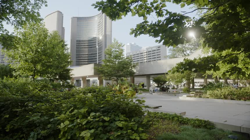 A modern glass walled building with walking paths and trees
