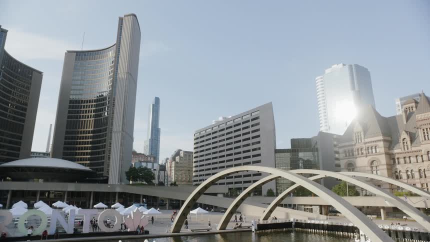 The toronto skyline near nathan phillips square surrounded by buildings and water